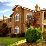 Photo showcasing stucco and stone building exterior with arched windows