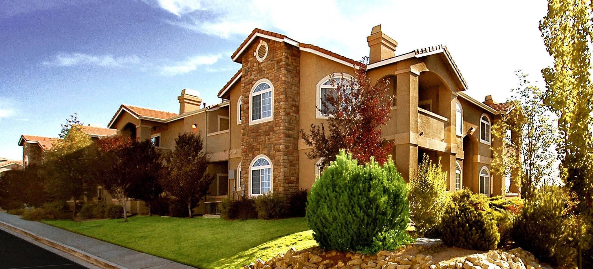 Photo showcasing stucco and stone building exterior with arched windows