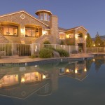 View of Aviana's clubhouse in the evening with the pool in the foreground. The illuminated clubhouse is reflected in the waters of the pool.