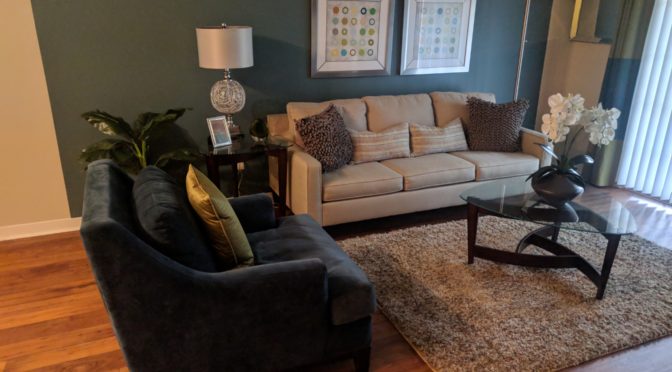 Cedar Bluff living room. Vinyl plank flooring. Sofa, sofa chair, and other furniture.