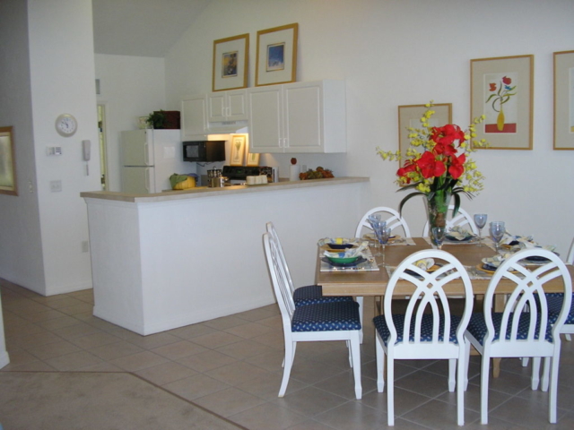 Kitchen and dining room in three bedroom flat. Porcelain tile floors in kitchen and dining area. Carpet in living room.